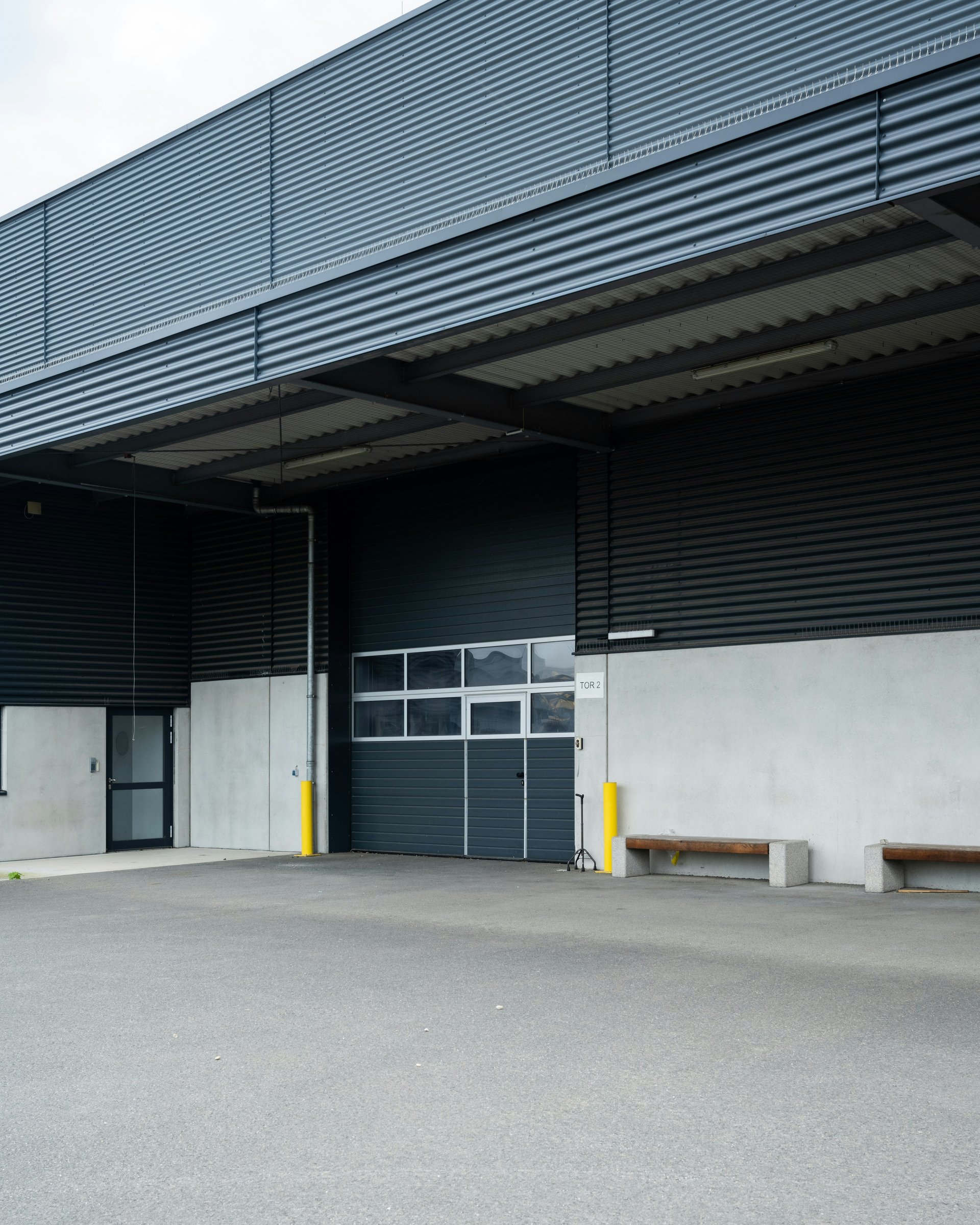 Portes sectionnelles motorisées anthracite sur bâtiment industriel moderne installées par FERMIS