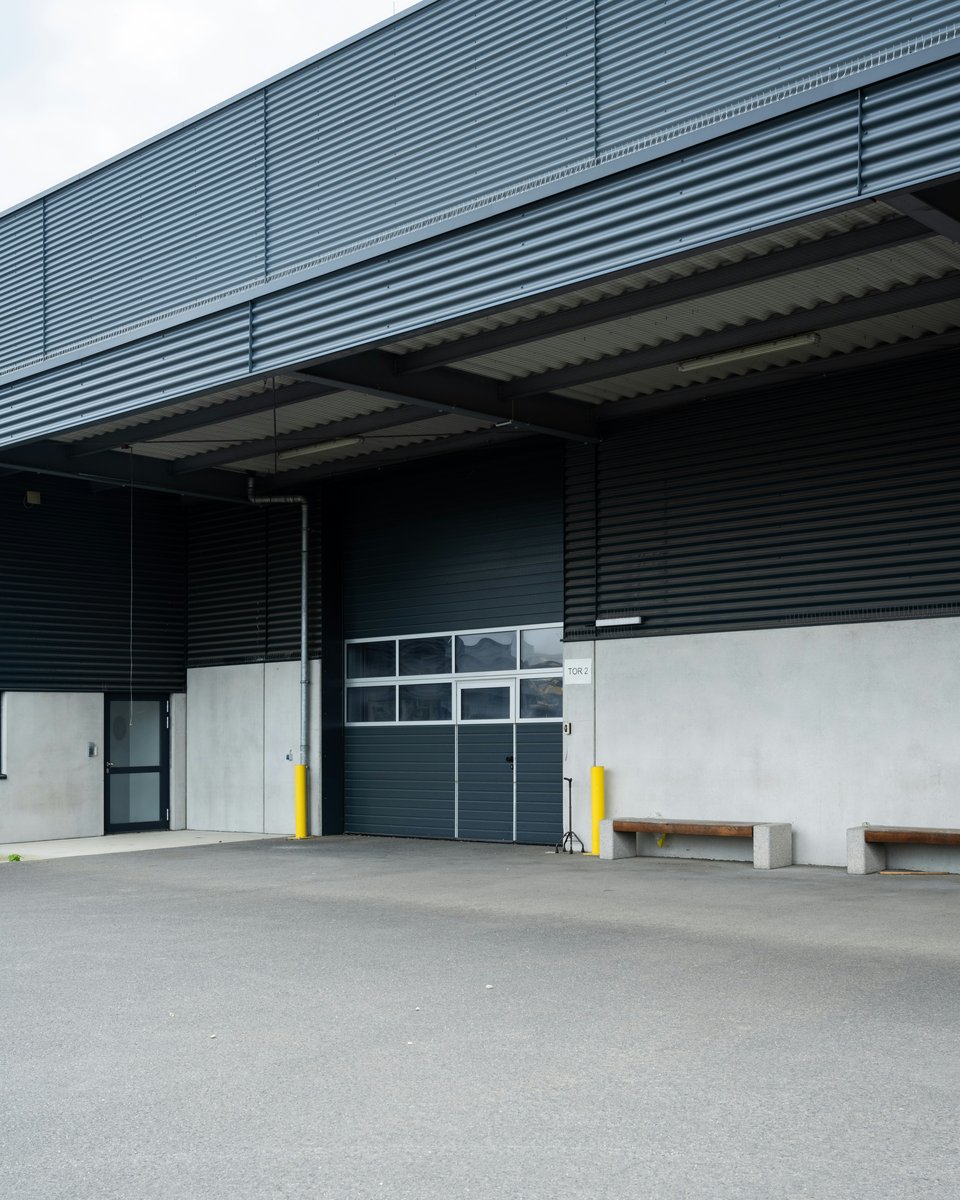 Portes sectionnelles motorisées anthracite sur bâtiment industriel moderne