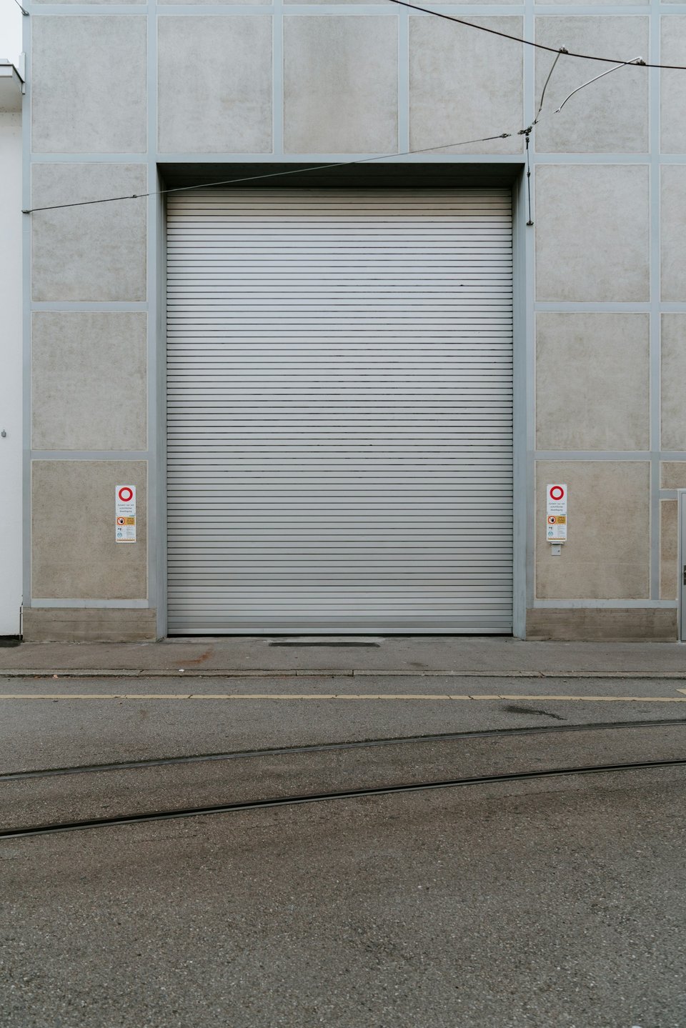 Porte rapide industrielle blanche sur façade béton — accès logistique professionnel